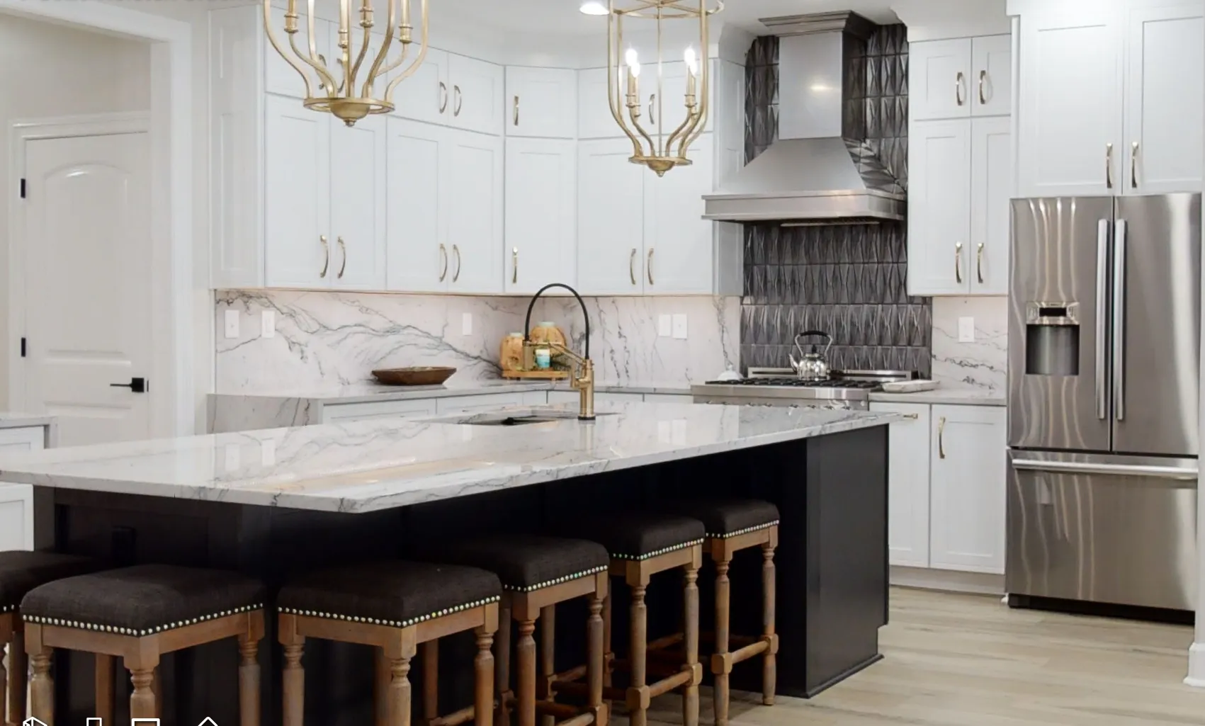 Custom designed kitcheb by HillCo Custom Homes with white countertops and white upper cabinets with a dark island